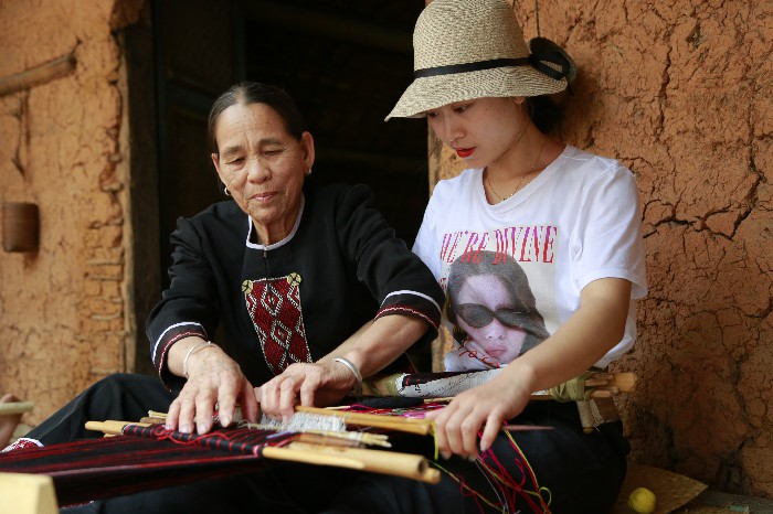 1、游客在和黎族文身阿婆學織黎錦 1、游客在和黎族文身阿婆學織黎錦